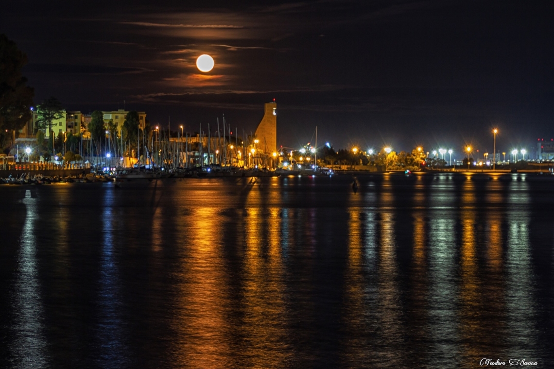 Veduta notturna del porto di Brindisi illuminato dalla luna.